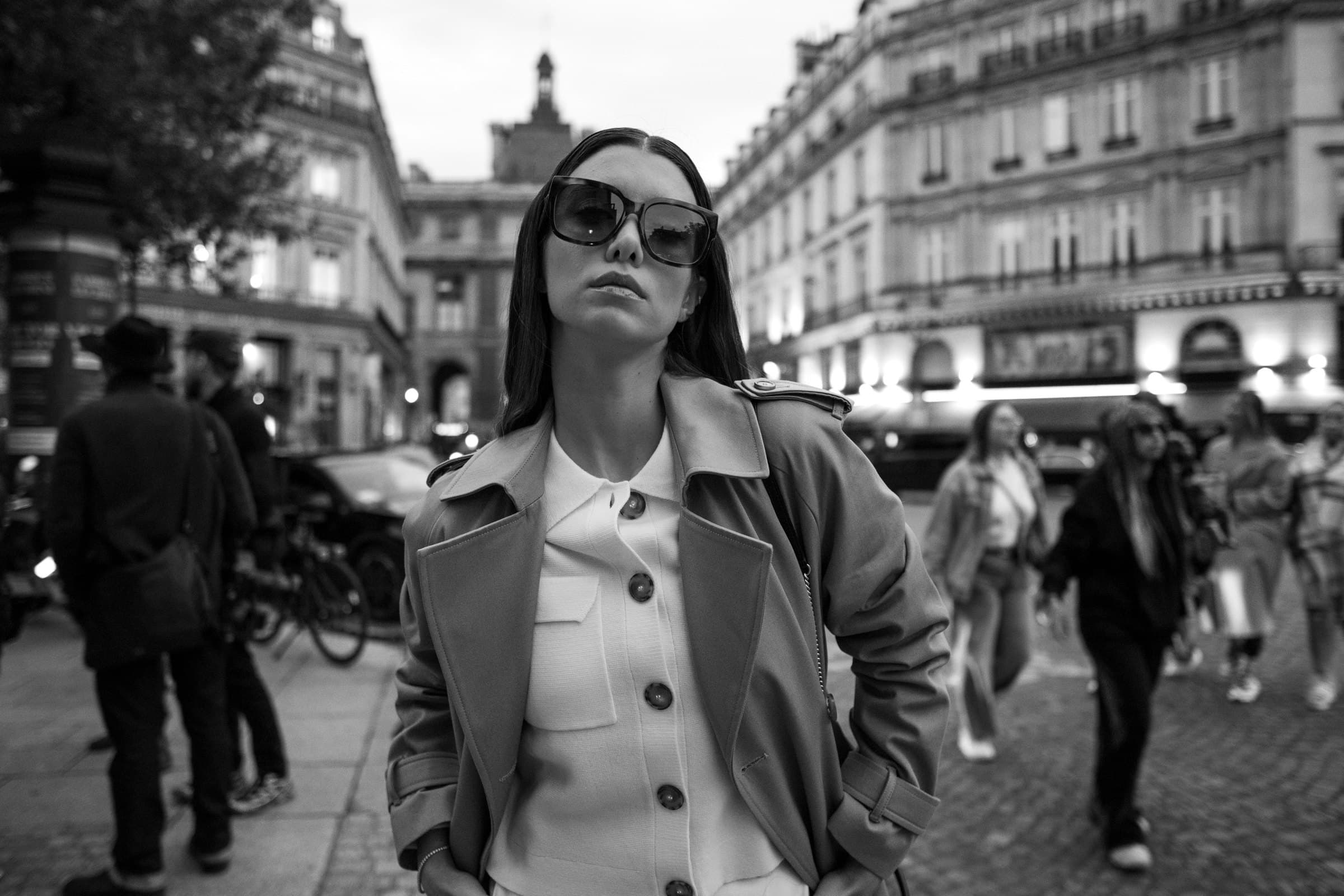 Femme en trench sur un boulevard parisien