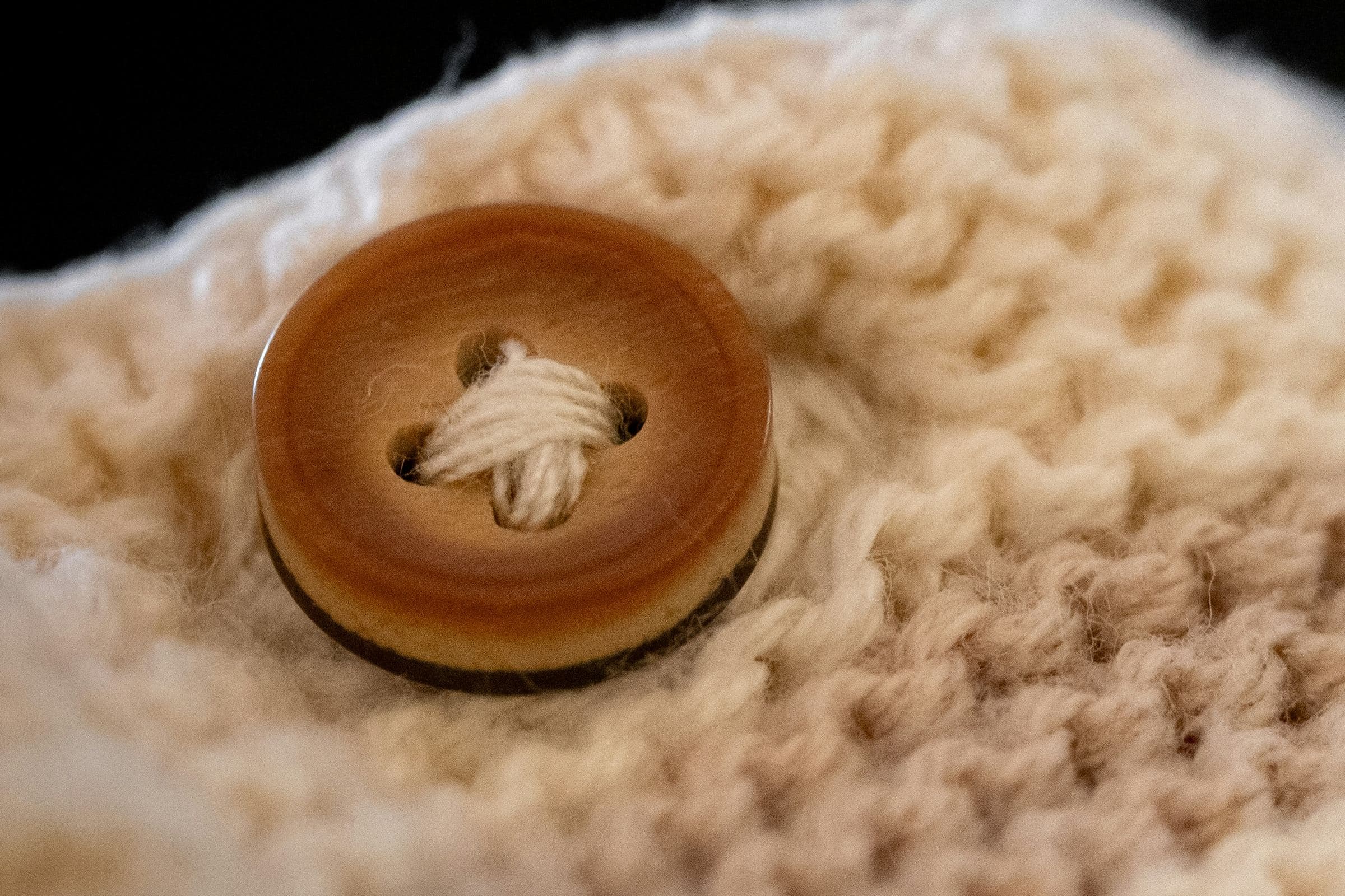 Bouton de corozo cousu sur une maille écrue